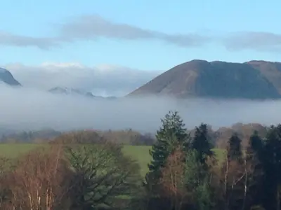 a view of a foggy valley with mountains and trees at Laurel Bank Guest House in Keswick