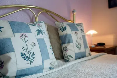 a bed with blue and white pillows on it at Laurel Bank Guest House in Keswick