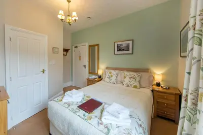 a bedroom with a bed with a book on it at Laurel Bank Guest House in Keswick