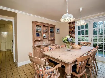a dining room with a wooden table and chairs at Country Home on Private Estate in Minishant