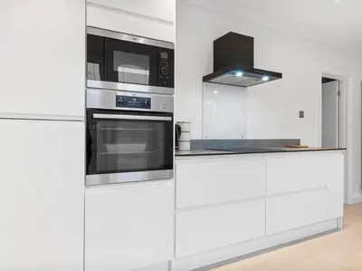 a white kitchen with stainless steel appliances at Modern & Stylish 2 Bed Home in Whitehaven in Whitehaven