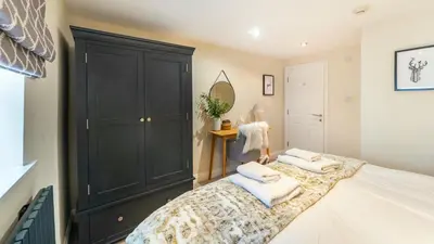 a bedroom with a large black cabinet and a bed at Derwentwater View in Portinscale
