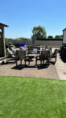 a group of benches and tables on a patio with grass at Bungalow with Hot Tub, BBQ Hut, Golf Net , Large Garden & Play Area in Maybole