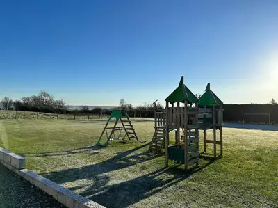 a playground with a slide and a swing set at Bungalow with Hot Tub, BBQ Hut, Golf Net , Large Garden & Play Area in Maybole