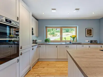 a large kitchen with white cabinets and a window at 4 Bed in Kippford 95234 in Kippford