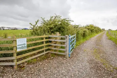 a fence on the side of a dirt road at Unit 2 - Carrock View Camping Pod in Carlisle