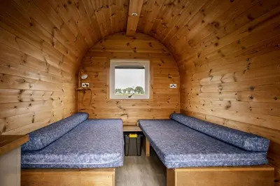 a room with two benches in a wooden room with a window at Unit 2 - Carrock View Camping Pod in Carlisle