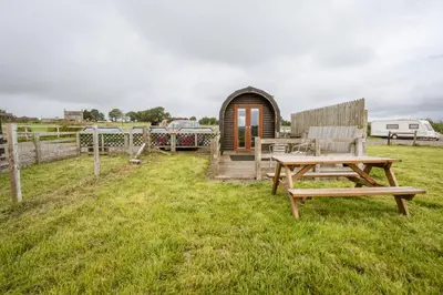 a wooden cabin with a picnic table and a bench at Unit 4 - Skiddaw View Camping Pod in Carlisle