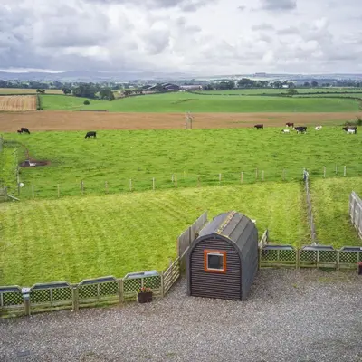 a small house in a field next to a fence at Unit 4 - Skiddaw View Camping Pod in Carlisle