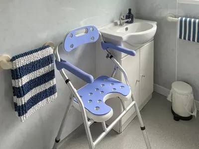 a blue chair in a bathroom next to a sink at Lilybank Cottage in Doularg