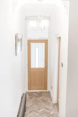 a hallway with a wooden door and a window at Luxury townhouse in Workington in Workington
