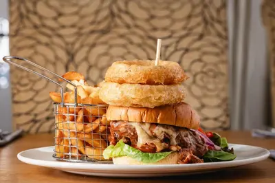 a sandwich on a plate with a basket of food at The Kellbank in Gosforth