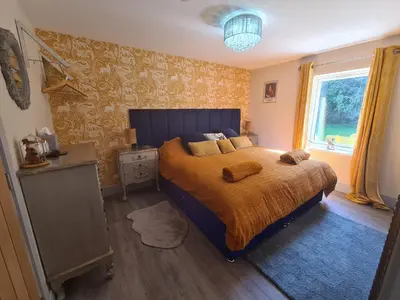 a bedroom with a bed with a yellow blanket and a window at The Den by Blake View Holidays a peaceful boutique retreat 3 miles from Ennerdale- standard twin or super-king bed available in Rowrah