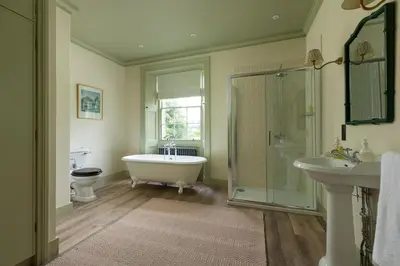 a bathroom with a tub and a toilet and a sink at Dabton House in Carronbridge