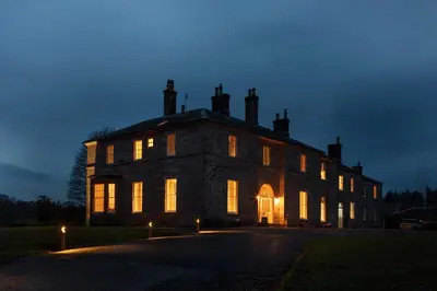 a large building with its lights on at night at Dabton House in Carronbridge