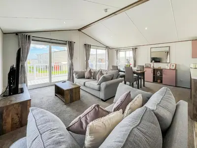 a living room with two couches and a table at Bud's Bay in Mainsriddle