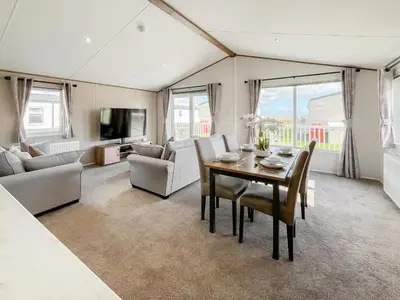 a living room with a table and chairs and a couch at Bud's Bay in Mainsriddle