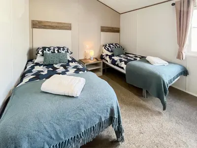 a bedroom with two beds with blue comforters at Bud's Bay in Mainsriddle