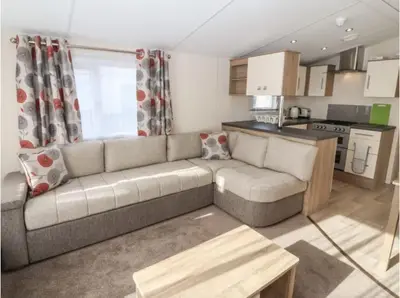a living room with a couch and a kitchen at Rhodes Retreat, Lake District in Brigham
