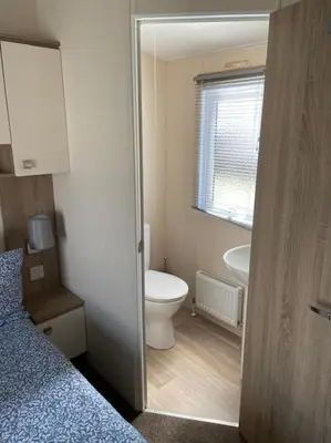 a small bathroom with a toilet and a sink at Rhodes Retreat, Lake District in Brigham