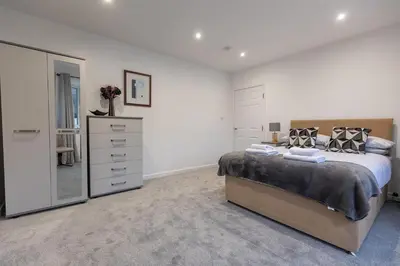 a bedroom with a large bed and a dresser at SHELTER STONE - Cottage in the heart of the Lakes in Keswick