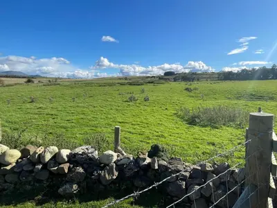 a fence in front of a field with a grass field at Lake District Stunning Lodge in Plumbland