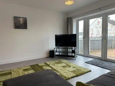 a living room with a tv and a large window at Chapel Terrace - 2 Bedrooms - Sleeps 4 in Cleator Moor