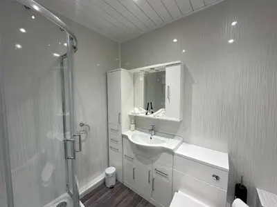 a white bathroom with a sink and a shower at Chapel Terrace - 2 Bedrooms - Sleeps 4 in Cleator Moor