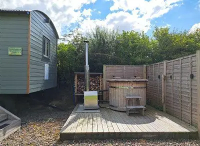 a wooden deck with a bench and a fence at Puddleduck Hut Armathwaite with hot tub and dog agility course, perfect for a romantic break in Armathwaite