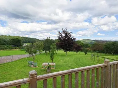 a park with a picnic table and benches in a field at Puddleduck Hut Armathwaite with hot tub and dog agility course, perfect for a romantic break in Armathwaite