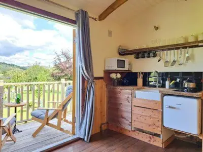 a kitchen with a view of a deck with a balcony at Puddleduck Hut Armathwaite with hot tub and dog agility course, perfect for a romantic break in Armathwaite
