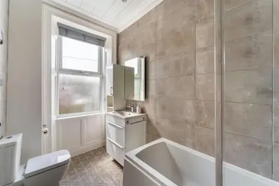 a bathroom with a tub and a toilet and a window at Mansefield, Keswick - Sleeps 6 in Keswick
