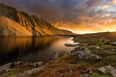 a sunset over a lake with a mountain at Gosforth Hall Inn in Gosforth