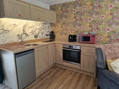 a small kitchen with a sink and a microwave at The Stables by Blake View Holidays, comprising The Nest, The Drey, The Burrow and the Den, 3 miles from Ennerdale in Rowrah