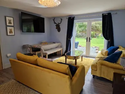 a living room with two yellow couches and a table at The Stables by Blake View Holidays, comprising The Nest, The Drey, The Burrow and the Den, 3 miles from Ennerdale in Rowrah