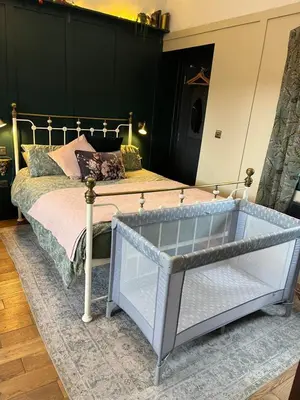 a bedroom with a bed with a metal frame at Dinmont Cottage in Dalston