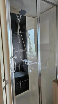 a bathroom with a shower and a sink at The Lake District Caravan in Lamplugh