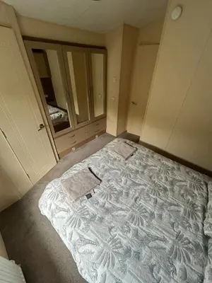 an empty bedroom with a large bed in a room at The Lake District Caravan in Lamplugh