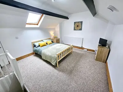 a bedroom with a bed and a clock on the wall at Ashley House, Carlisle in Carlisle