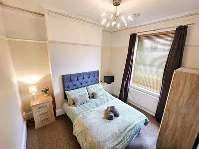 a bedroom with a bed with a teddy bear on it at Ashley House, Carlisle in Carlisle
