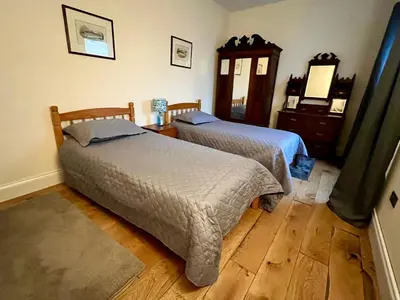a bedroom with two beds and a dresser at Ryehill with Fishing in Sanquhar