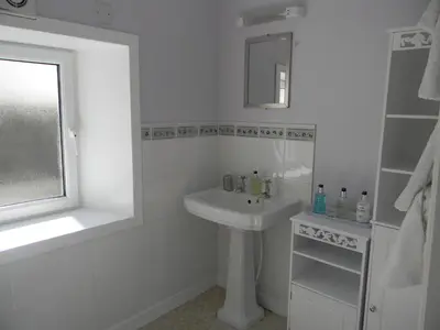 a white bathroom with a sink and a mirror at Harbour Lights Guesthouse in Stranraer