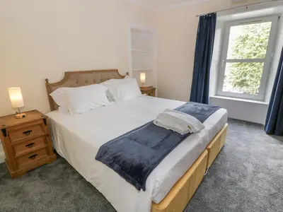 a bedroom with a large bed and a window at West Morton House in Thornhill