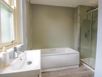 a bathroom with a tub and a sink and a shower at Kilnmark Farmhouse in Thornhill
