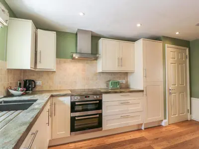 a kitchen with white cabinets and a stove top oven at The Suite in Thornhill