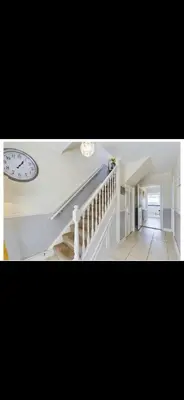 a room with a staircase and a clock on the wall at Beach villa in Parton
