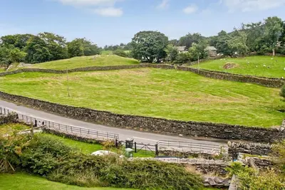 a road in a field next to a hill at Stylish retreat in Langdale in Chapel Stile