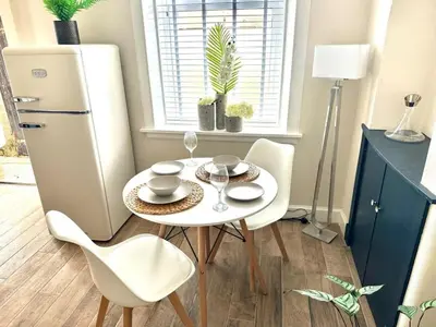 a white table and chairs in a kitchen with a refrigerator at Prestwick KingB PetsOk FreeP Wifi Tv in Prestwick