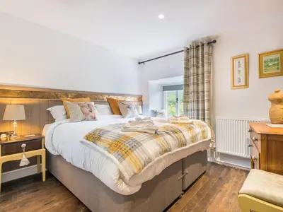 a bedroom with a large bed and a window at 4 Bed in Ulpha SZ183 in Ulpha