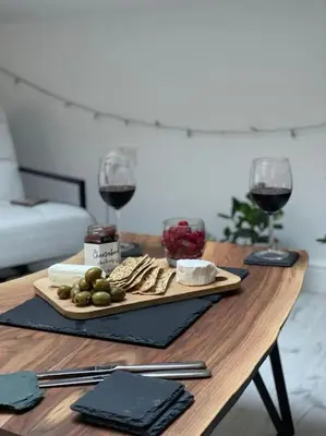 a table with a plate of food and two glasses of wine at Lakes Loft in Cockermouth